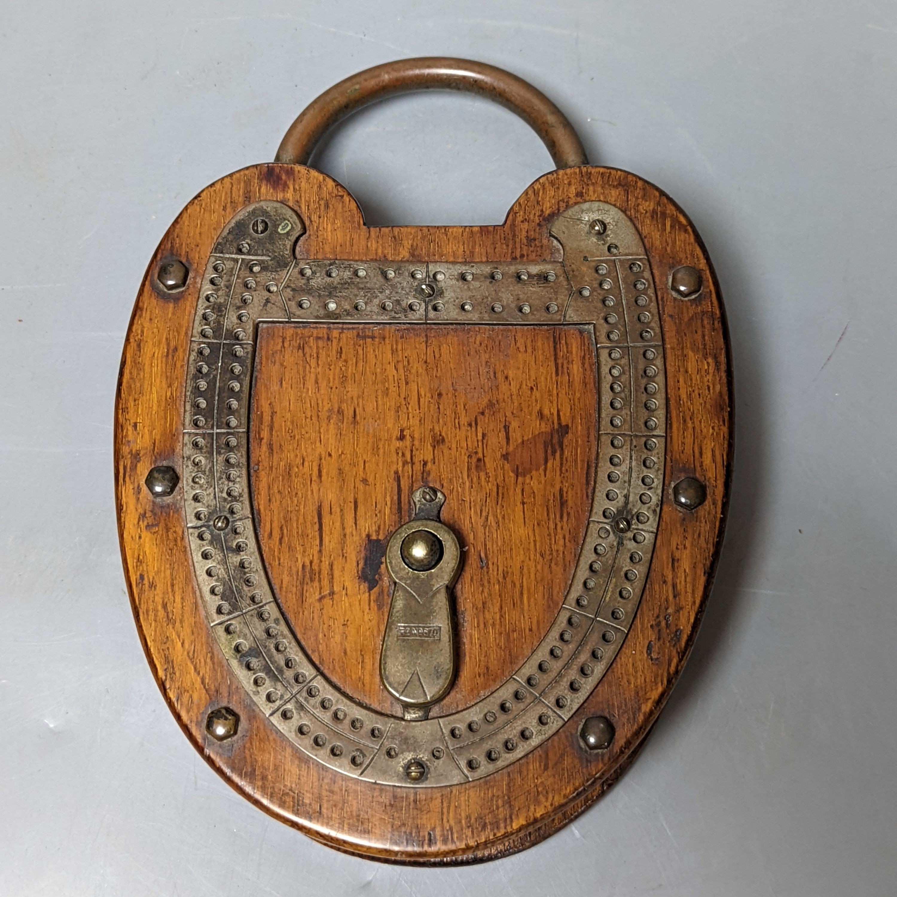 An unusual oak padlock-shaped cribbage board 22cm